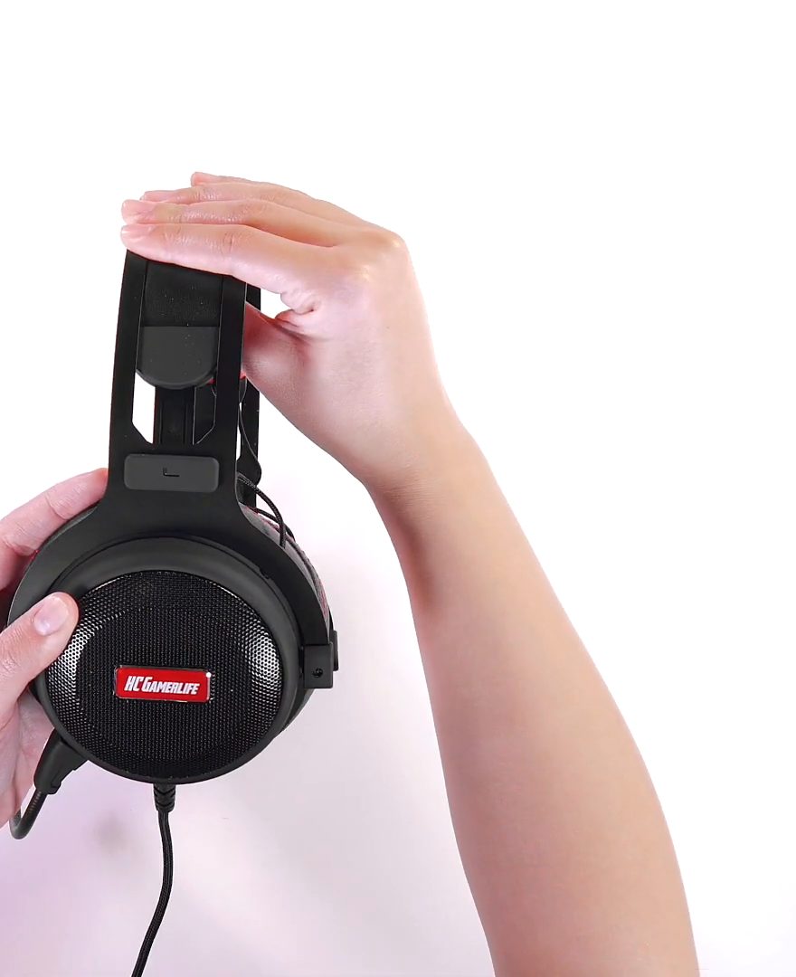 Hands holding the HCG1 in true side profile, showing palm-scale ear cups